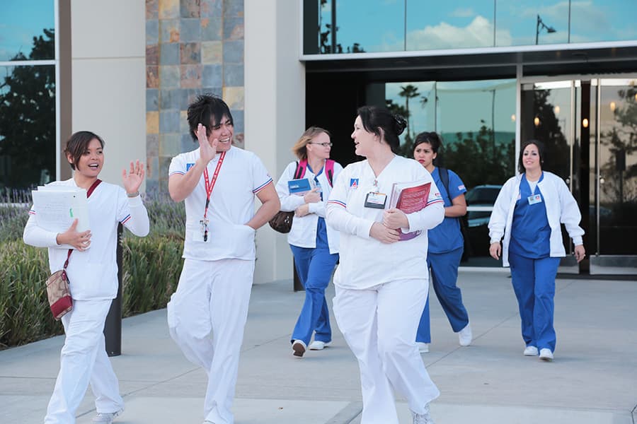 Summit College Medical Assistant and Nursing students smiling and laughing as they exit their school.