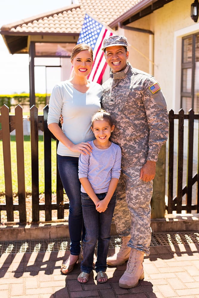 A military family standing and smiling