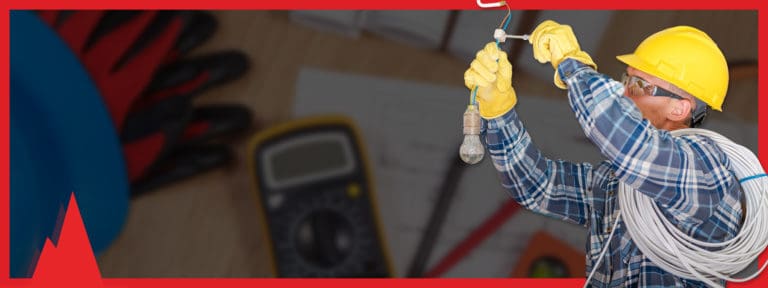 An electrician fixing a wire on a lightbulb